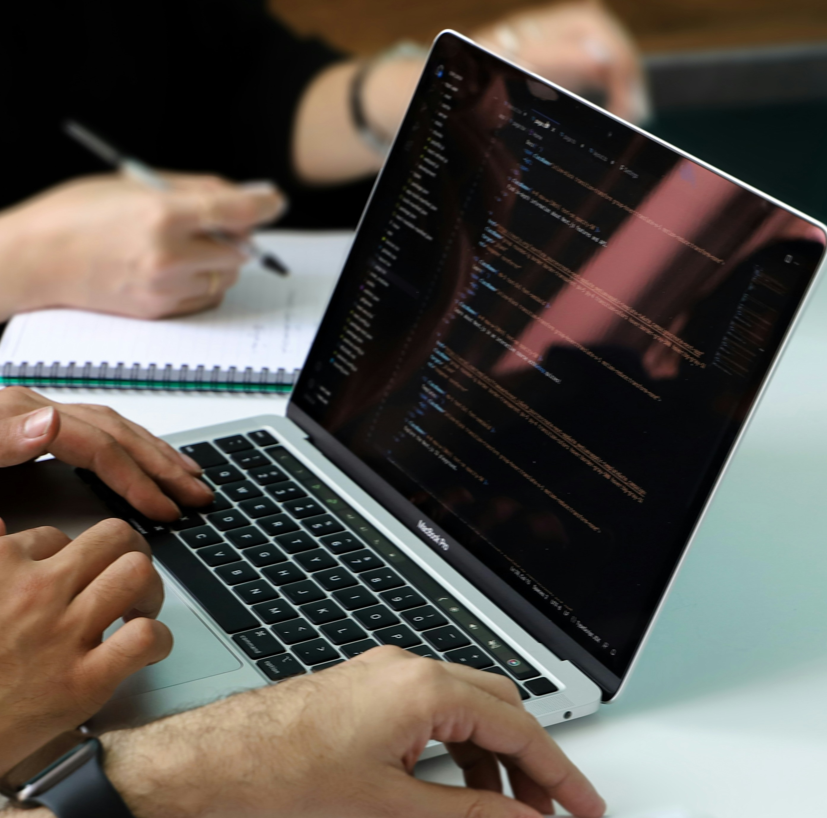 Stock photo showing people working on a laptop screen.